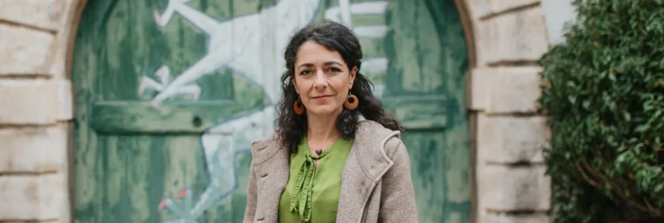 Sandra Krautwaschl im Landhaushof vor einem Tor mit der Abbildung des steirischen Panthers.