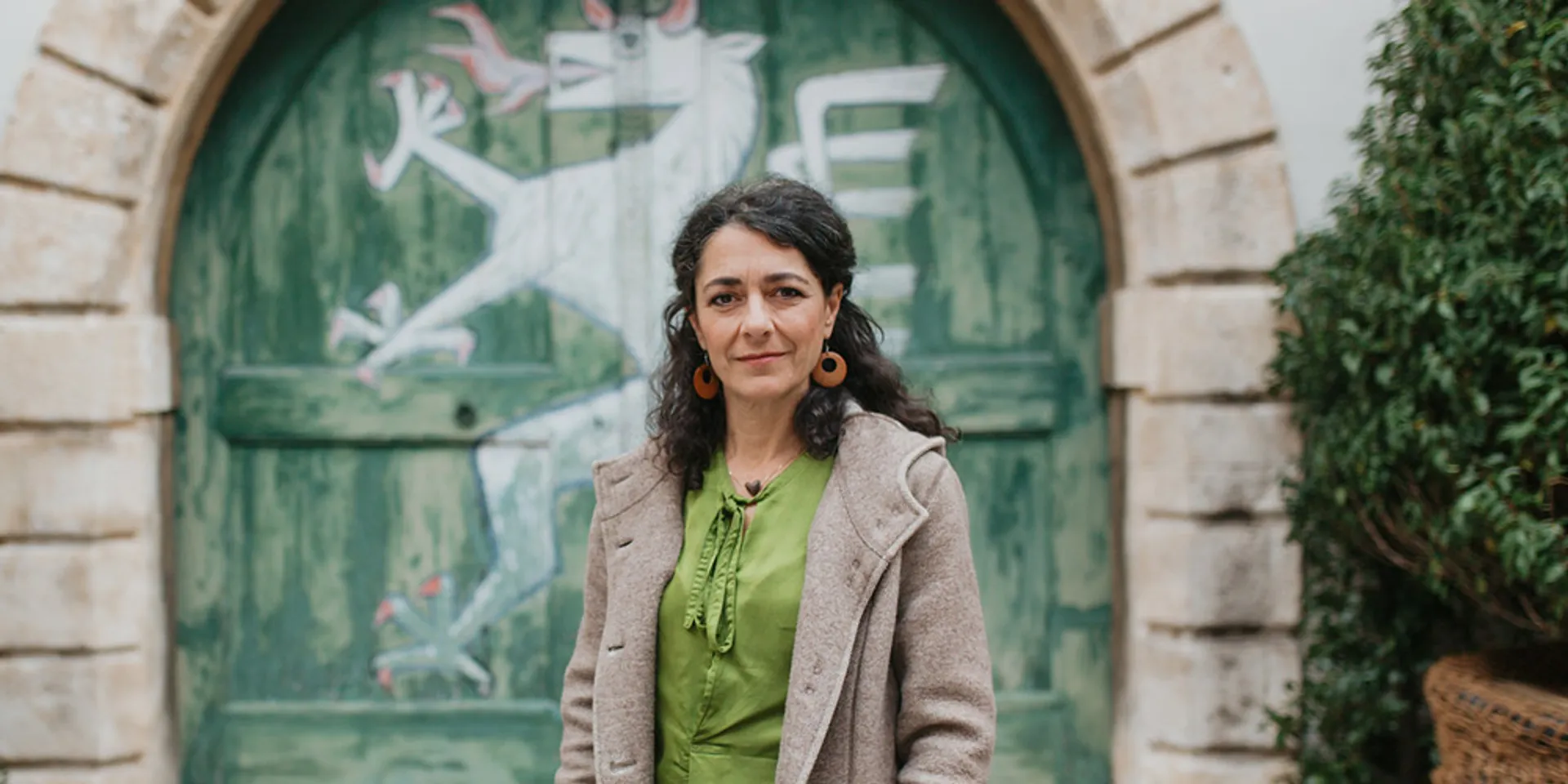 Sandra Krautwaschl im Landhaushof vor einem Tor mit der Abbildung des steirischen Panthers.