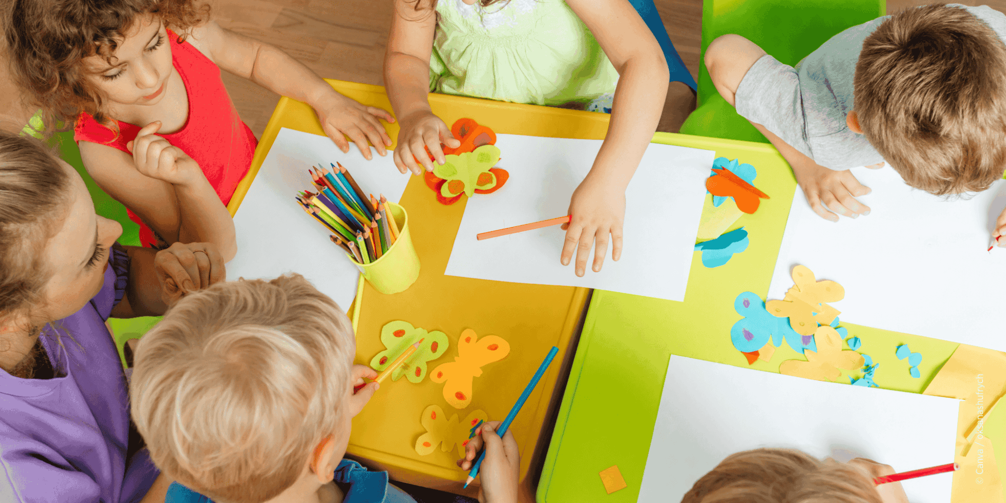 Kinder im Kindergarten malen und basteln. Ansicht von oben.