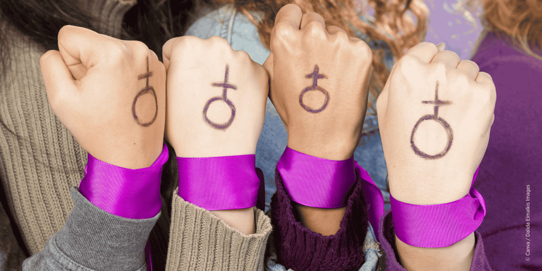 Mädchen halten fäuste in der Luft, auf denen das Zeichen für Frauen aufgezeichnet wurde.