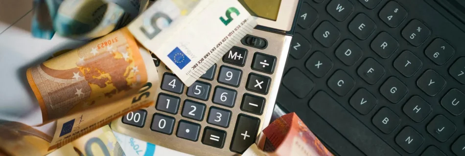 Euro-Scheine auf Computer-Tastatur und Taschenrechner