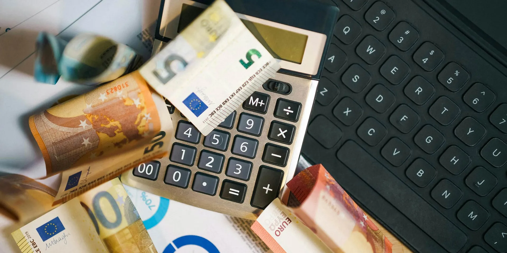 Euro-Scheine auf Computer-Tastatur und Taschenrechner