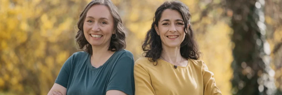 Susanne Sinz und Sandra Krautwaschl Schulter an Schulter vor herbstlichem Wald