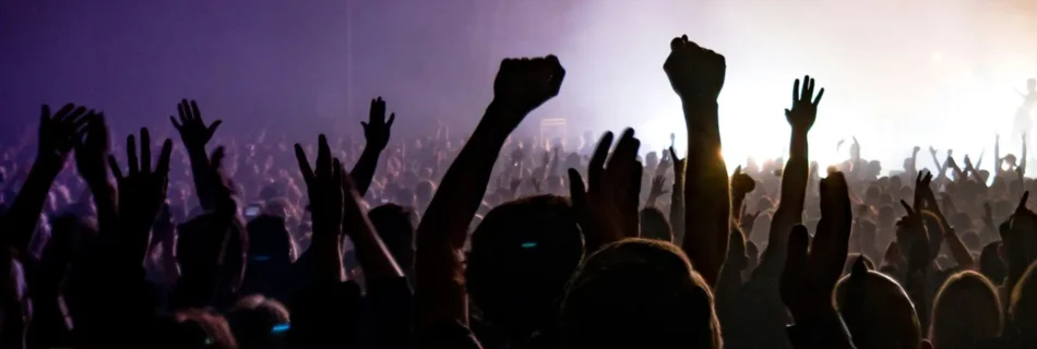 Hochgehobene Hände von Zuschauer:innen auf einem Konzert