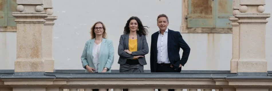 Landtagsabgeordnete Nitsche, Krautwaschl und Schönleitner stehen auf den Arkaden des Landhauses in Graz. Positiver Blick in die Kamera