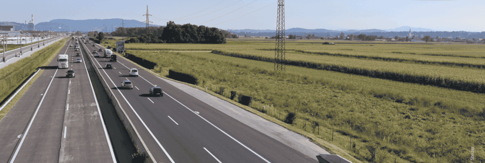 A9 Autobahn im Süden von Graz. Ein paar Autos befinden sich auf der Autobahn, daneben befinden sich Felder.