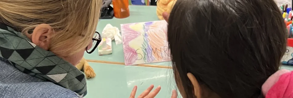 Landtagsabgeordnete Veronika Nitsche mit einem Kind (beide von hinten zu sehen) im Lerncafé Gries