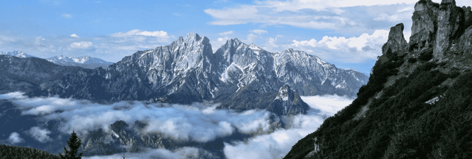Spektakuläre alpine Berglandschaft des Naturpark Gesäuse mit Berggipfeln, die aus einem Wolkenmeer herausragen.