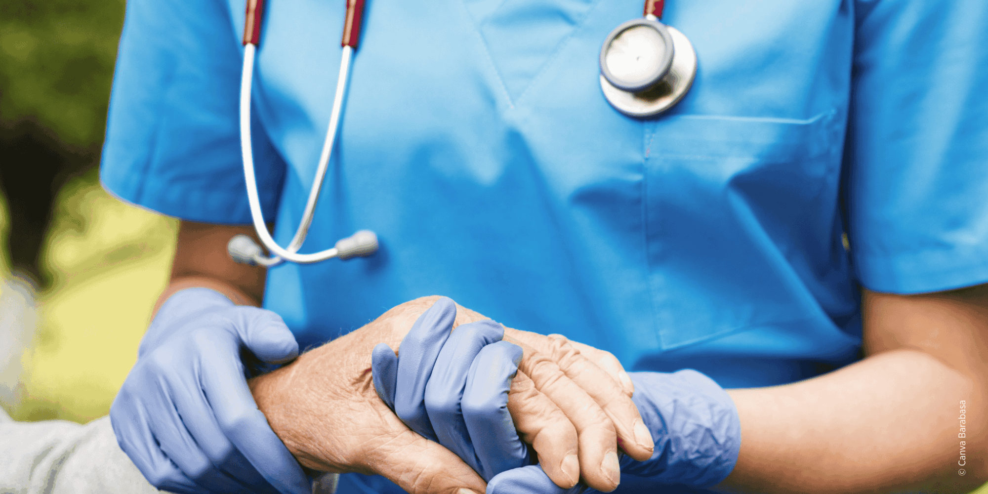 Pflegekraft hält Hand einer älteren Person