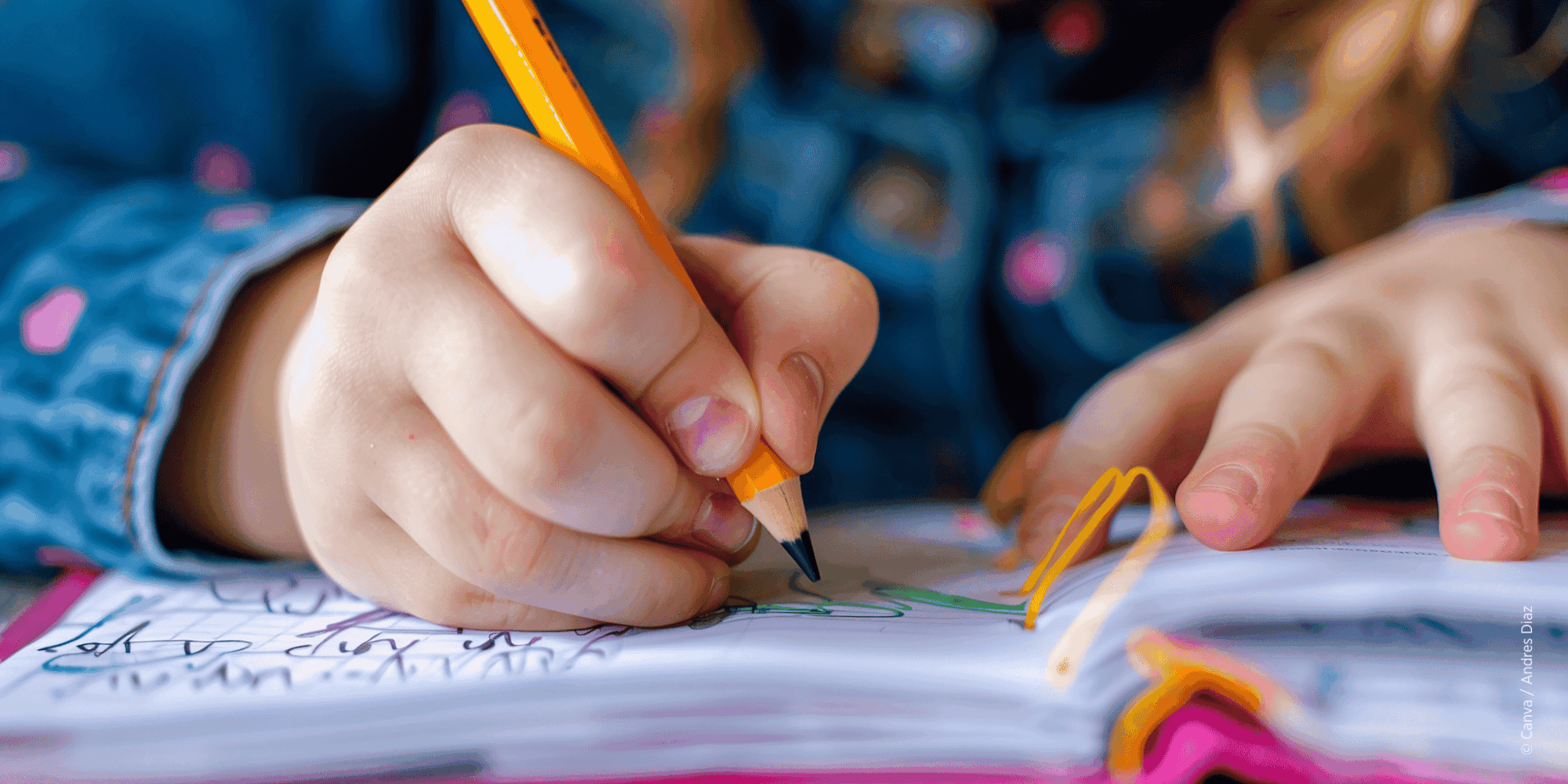 Kinderhände halten einen Stift mit schwarzer Spitze und zeichnen damit auf einem pinken Block mit weißen Blättern.