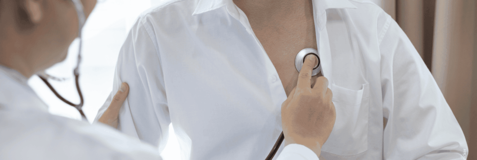 Arzt untersucht die Lungen eines Patienten mit dem Stethoskop.