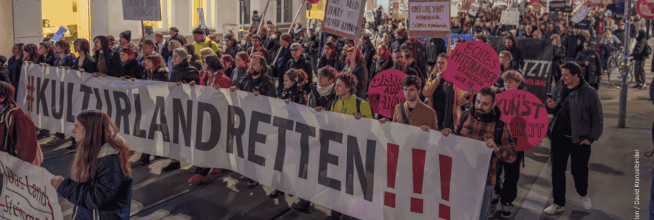 Demonstrant:innen in der Grazer Annenstraße mit großen Banner "#kulturlandretten!!!" und kleinen Demonstrationsschildern.