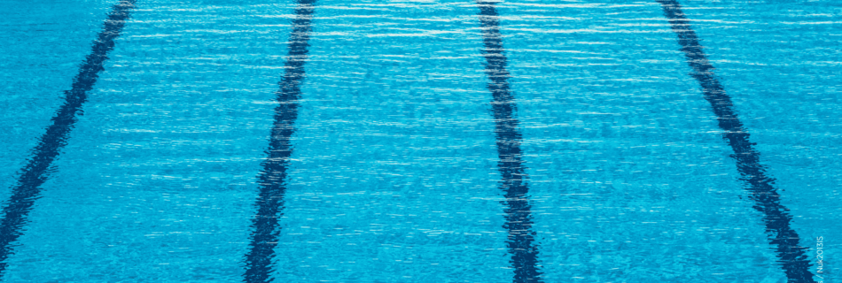 Nahaufnahme eines Schwimmbeckens mit dunkelblauen Bahnen – Symbol für leistbare Freizeit und soziale Teilhabe.