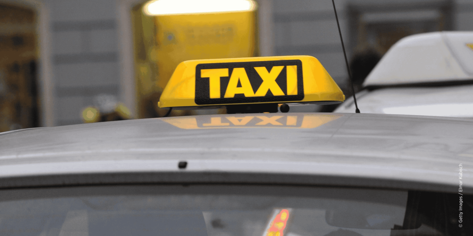 Leuchtendes Taxi-Schild auf einem Taxi in der Stadt.