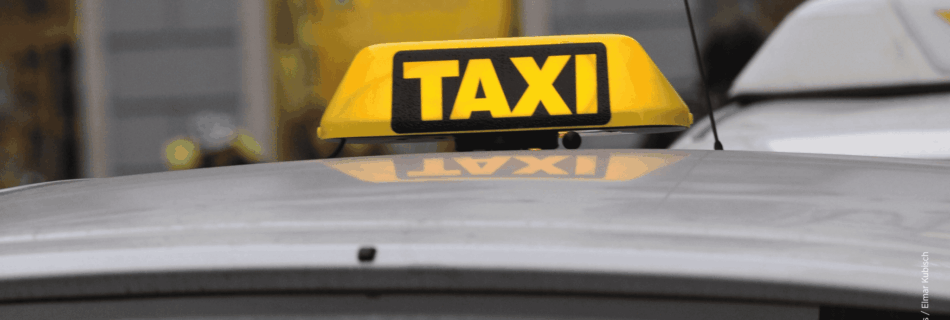 Leuchtendes Taxi-Schild auf einem Taxi in der Stadt.