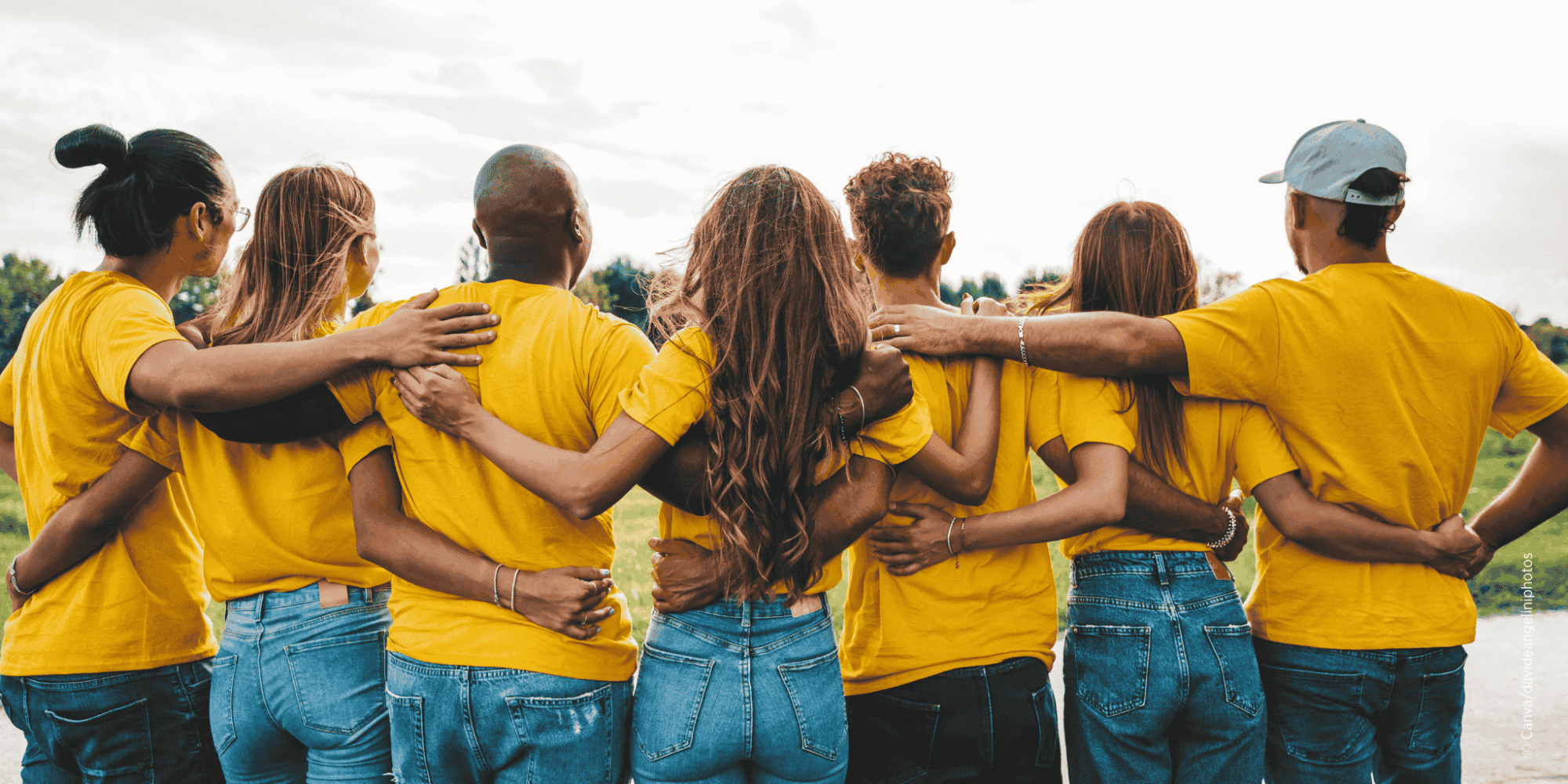 Gruppe junger Menschen hält sich an den Schultern als Zeichen von Zusammenhalt und Gemeinschaft
