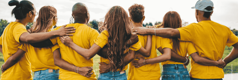 Gruppe junger Menschen hält sich an den Schultern als Zeichen von Zusammenhalt und Gemeinschaft