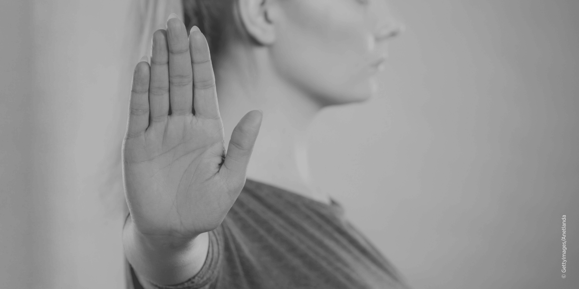 Frau hebt die Hand als Zeichen gegen Gewalt an Frauen und Femizide.