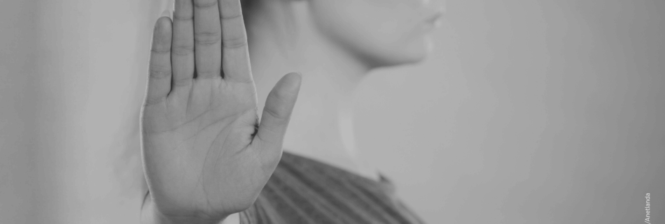 Frau hebt die Hand als Zeichen gegen Gewalt an Frauen und Femizide.