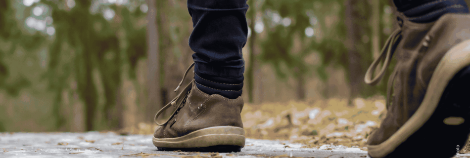 Person geht auf einem Gehweg entlang einer Straße – Symbolbild für sichere Gehwege und Fußverkehr