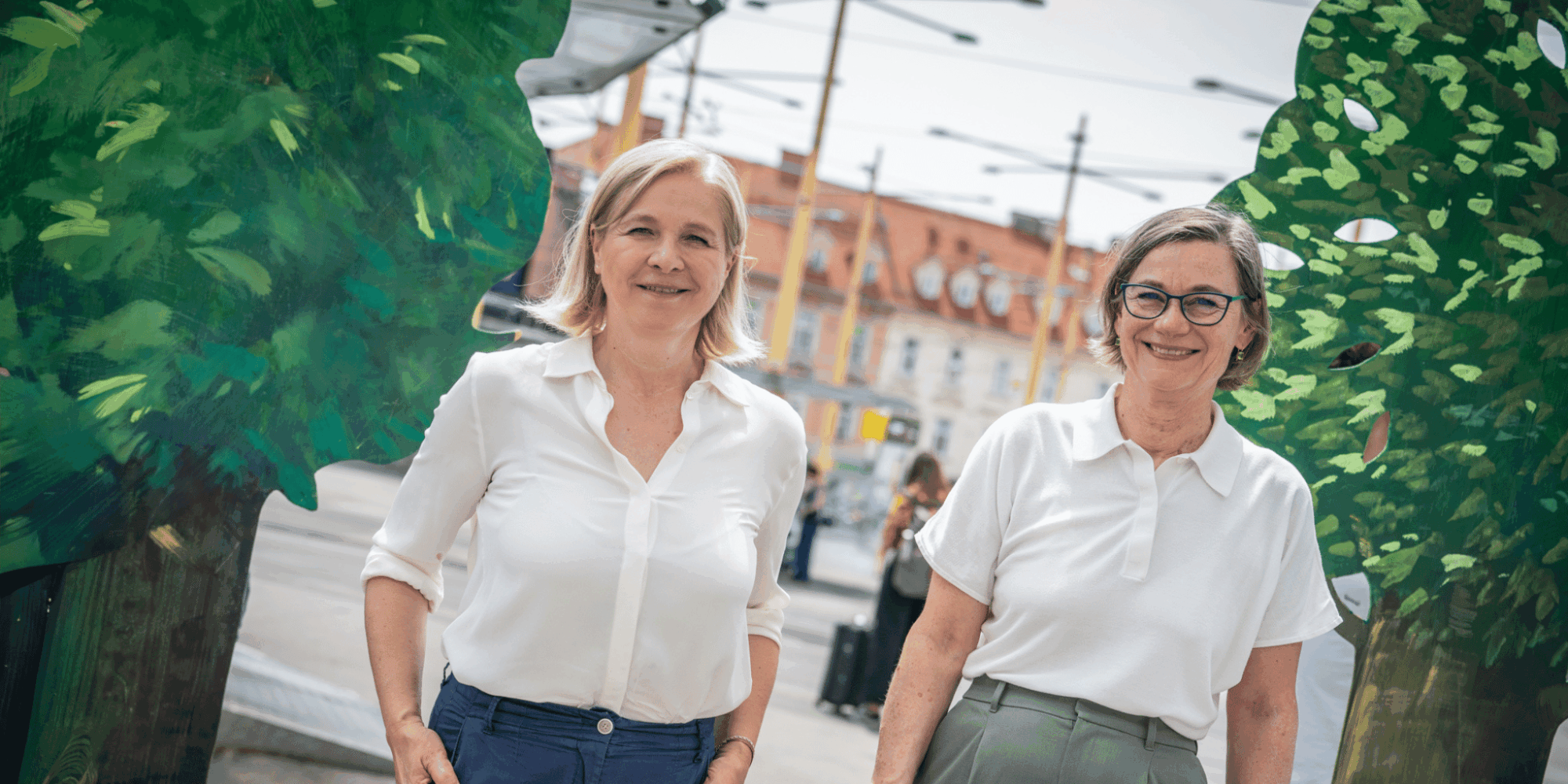 Judith Schwentner und Alexandra Würz-Stalder präsentieren Initiative Grün verbindet Graz am Jakominiplatz, Bäume im Hintergrund