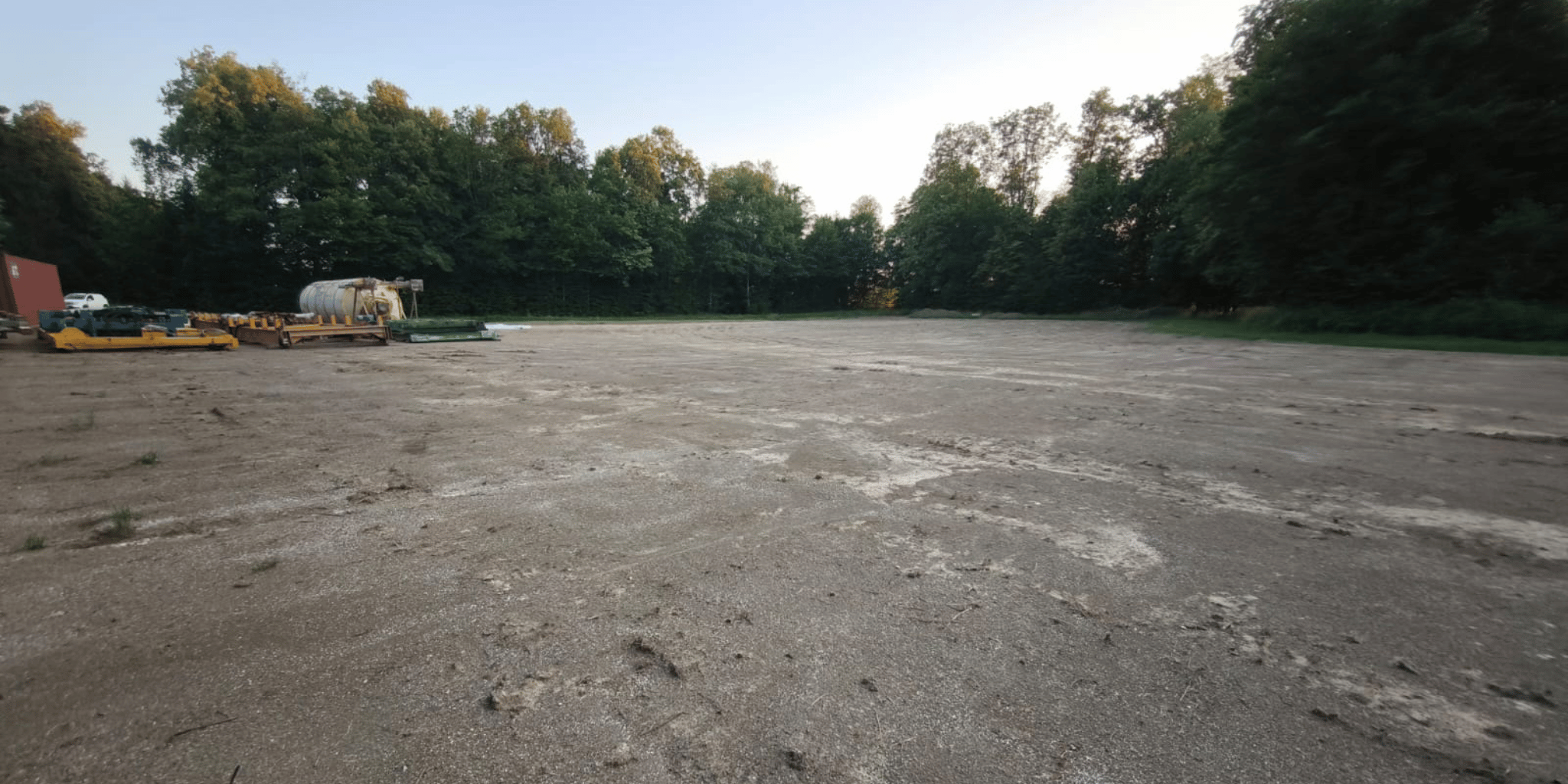 Planierte Freifläche mit Baumaschinen und Lagermaterial am Waldrand in Sulzegg