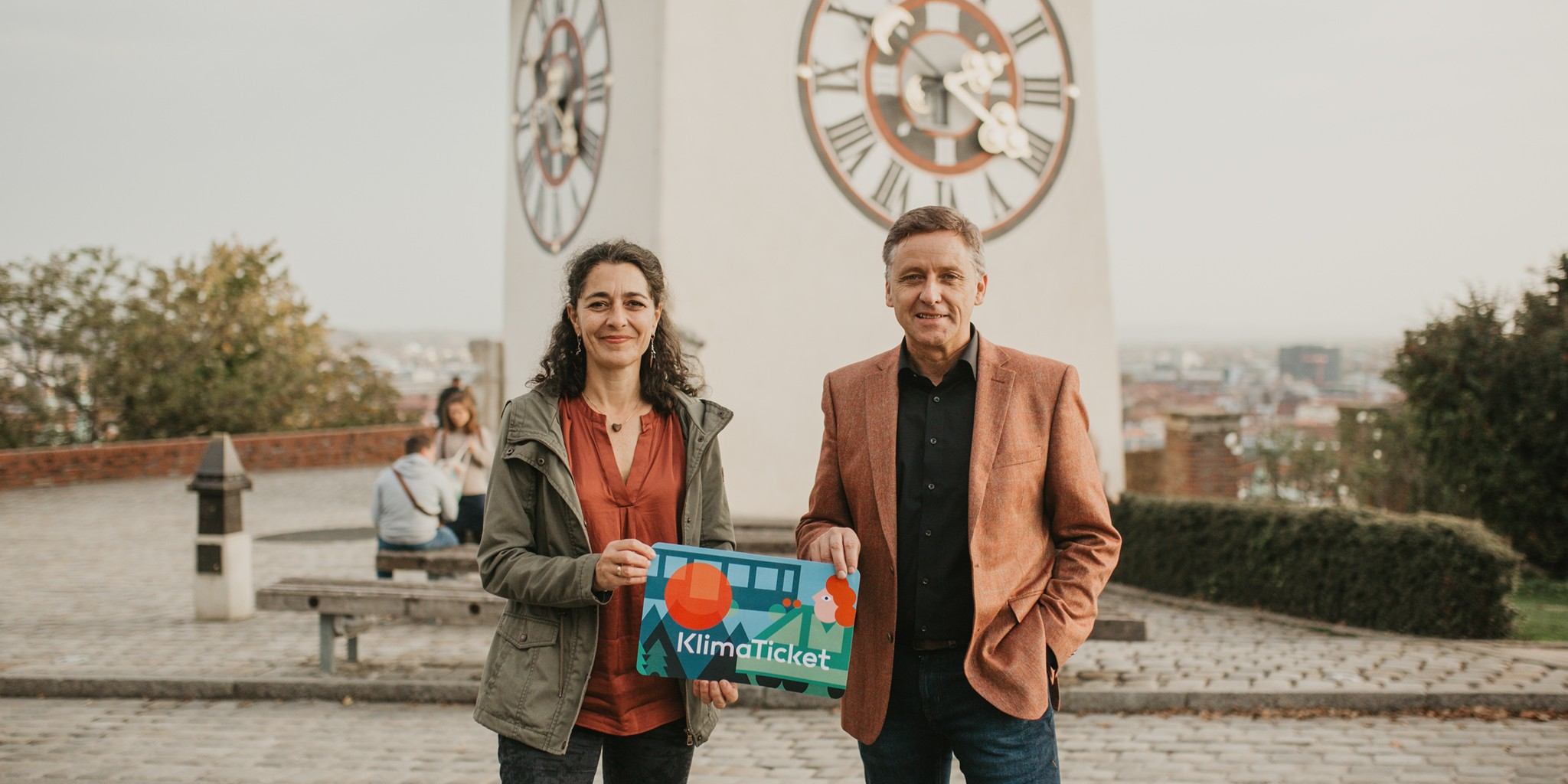 Zu sehen sind Klubobfrau Sandra Krautwaschl und Verkehrssprecher Lambert Schönleitner mit einem Schild eines Klimatickets.