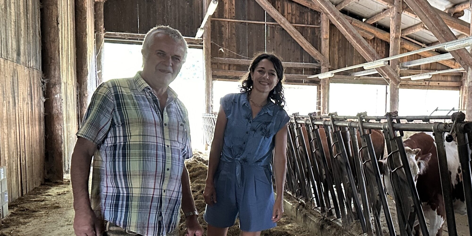 Zu sehen sind Klubobfrau Sandra Krautwaschl und der Biobauer Andreas Handlos. Sie stehen in dessen Kuhstall.