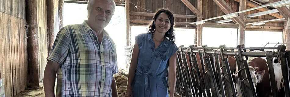 Zu sehen sind Klubobfrau Sandra Krautwaschl und der Biobauer Andreas Handlos. Sie stehen in dessen Kuhstall.