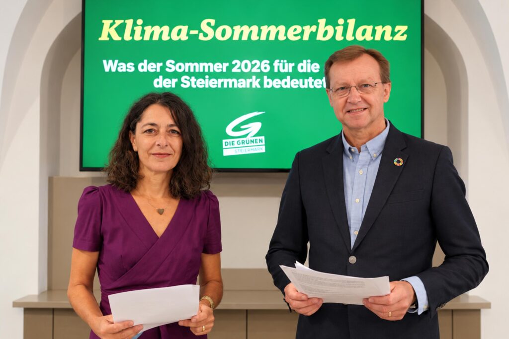 Sandra Krautwaschl und Gottfried Kirchengast stehen vor einem grünen Bildschirm mit der Aufschrift „Klima-Sommerbilanz – Was der Sommer 2026 für die Steiermark bedeutet“. Beide halten Unterlagen in den Händen.