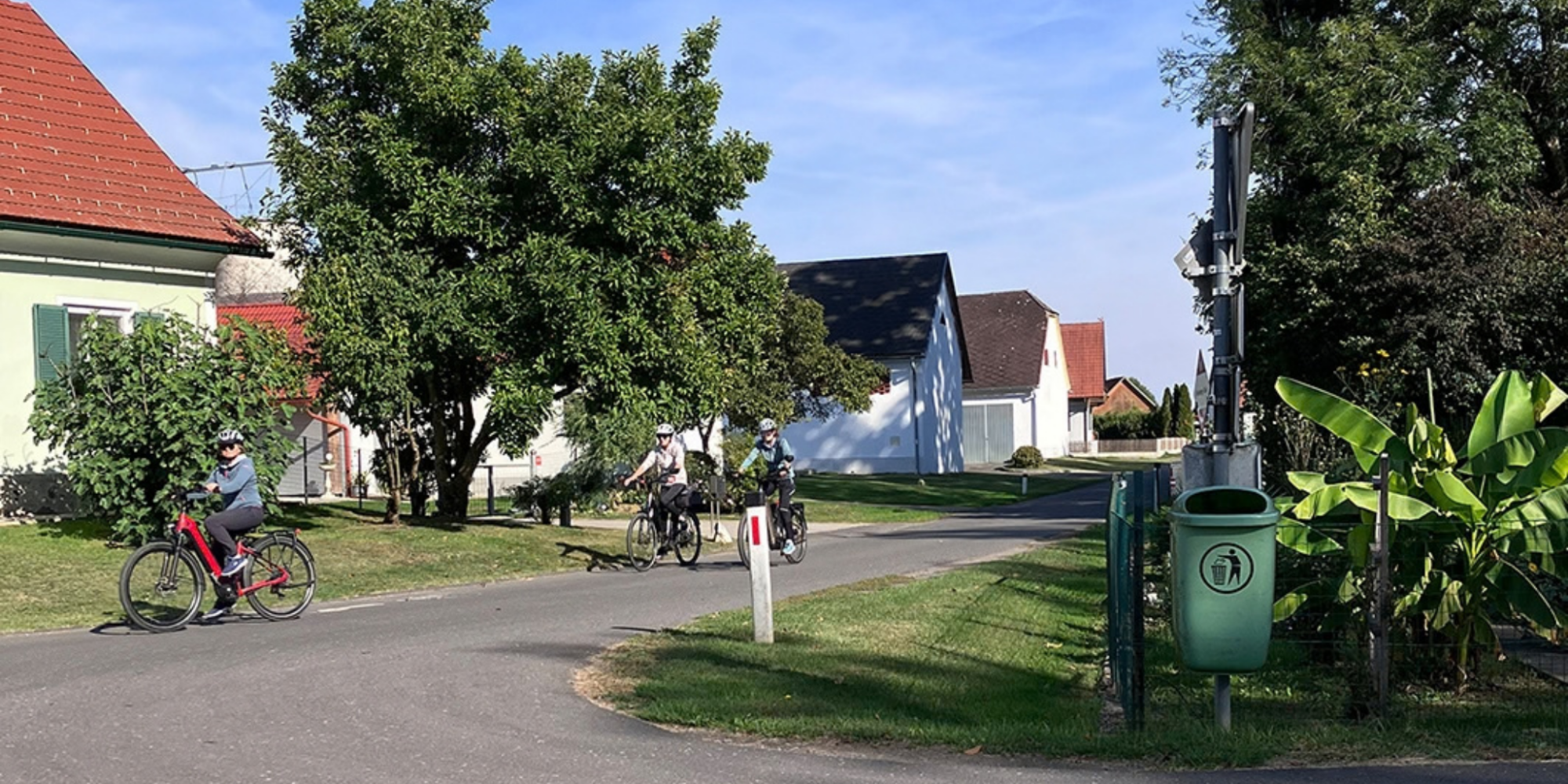 Radfahrer:innen auf der schmalen Ortsstraße in Donnersdorf, Gemeinde Halbenrain